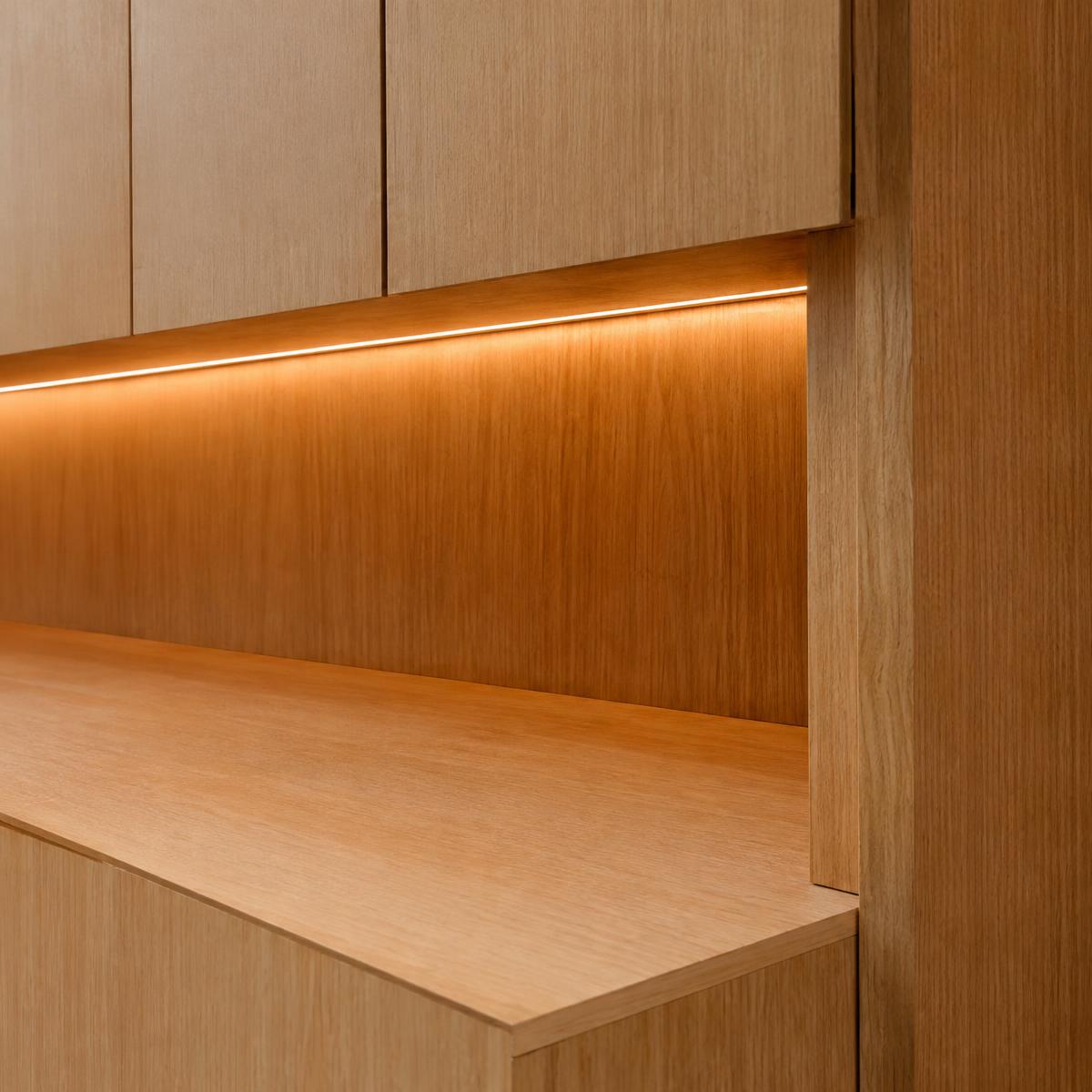 Detalhe de marcenaria em madeira com iluminação linear embutida